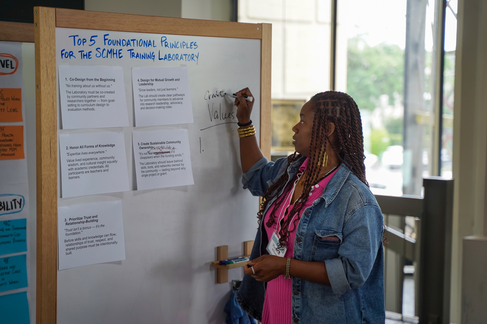 Design sprint in progress — woman writing on whiteboard